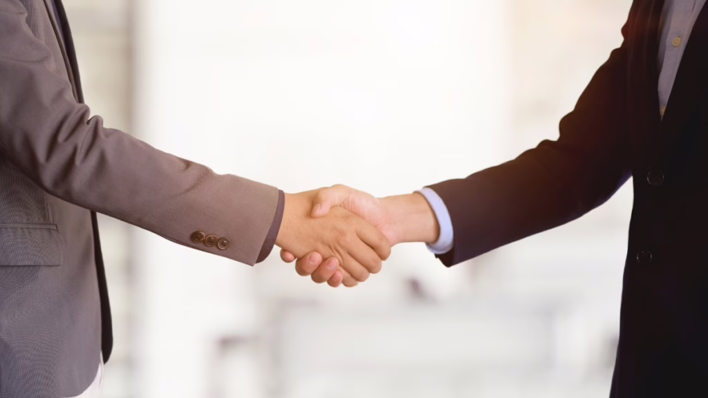 Close-up of a professional handshake, illustrating how constructive conflict can lead to building trust and stronger partnerships.